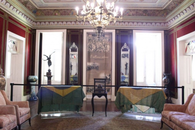 Ataúde que contém a máscara mortuária de Rui Barbosa, ladeado pelas duas bandeiras do Brasil